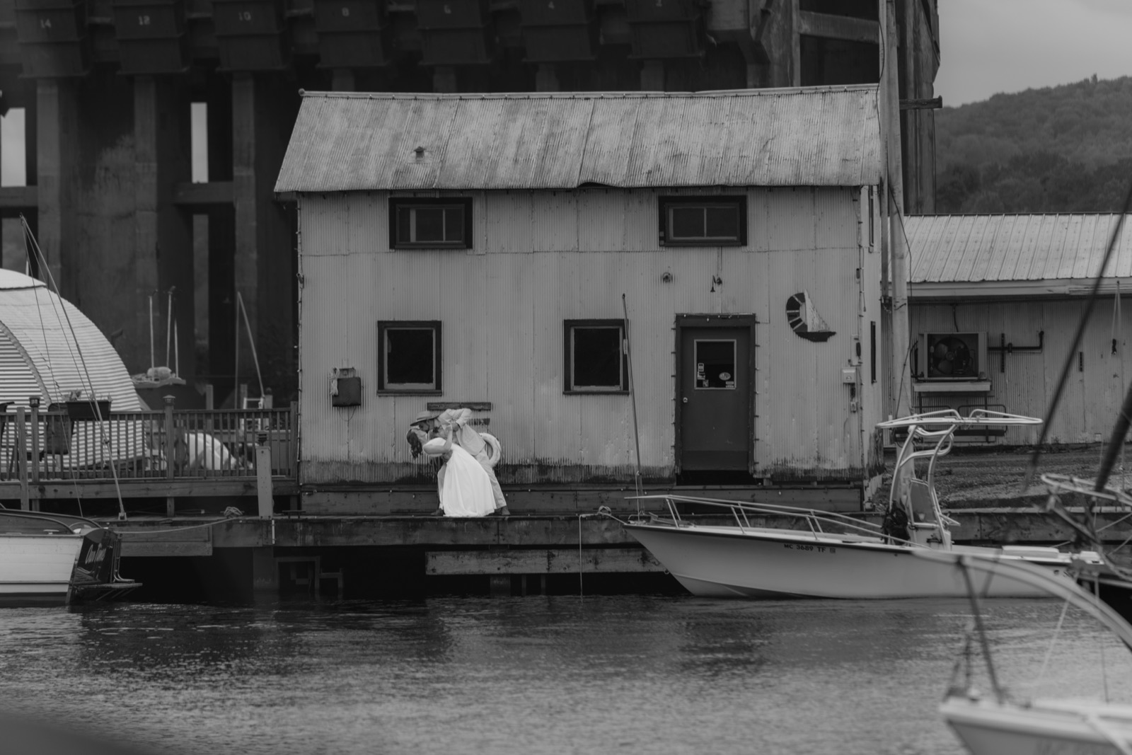 Black and white wedding photo by a waterfront building