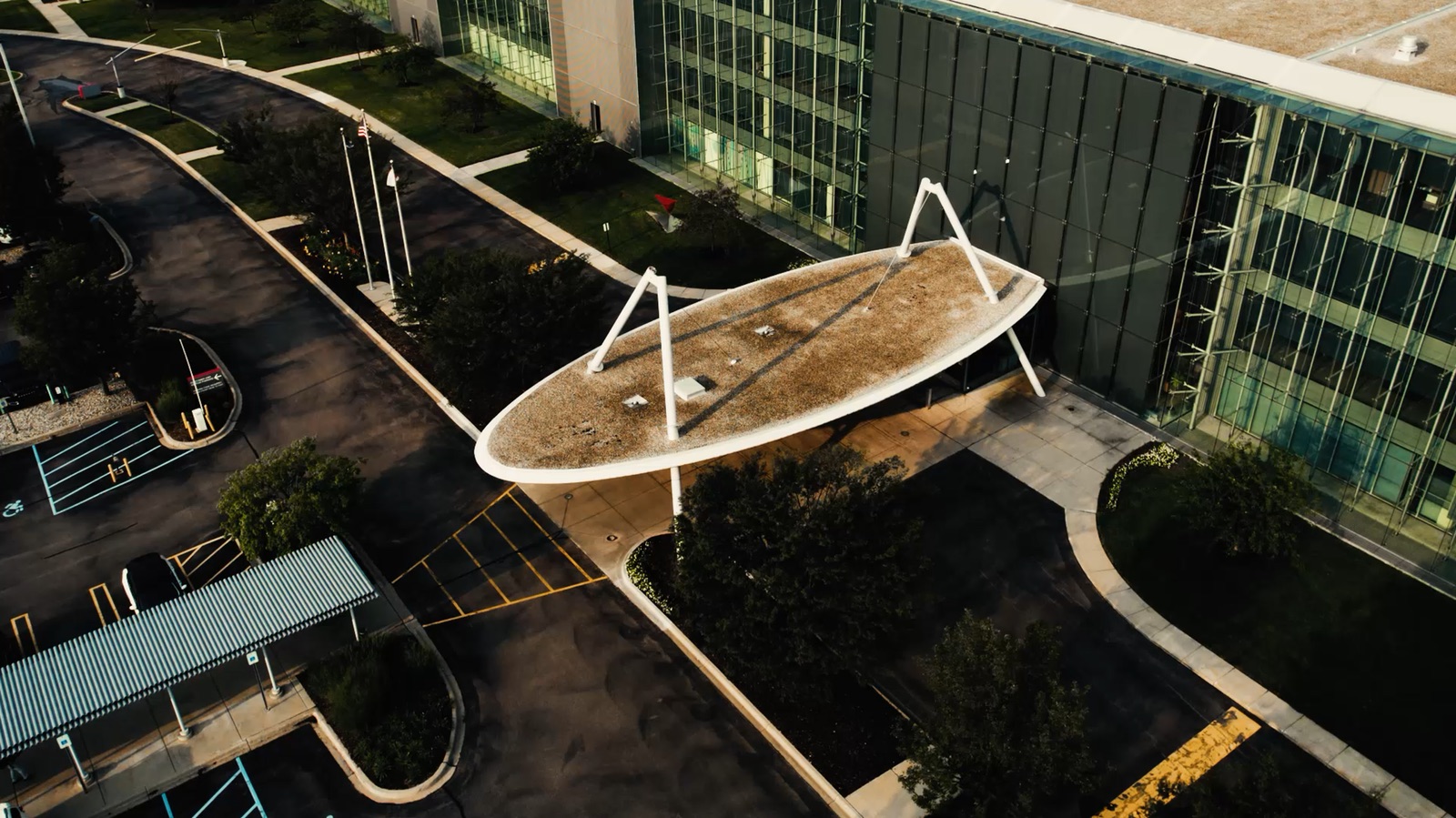 Drone shot of the Yazaki building and its oval canopy on A-frame legs