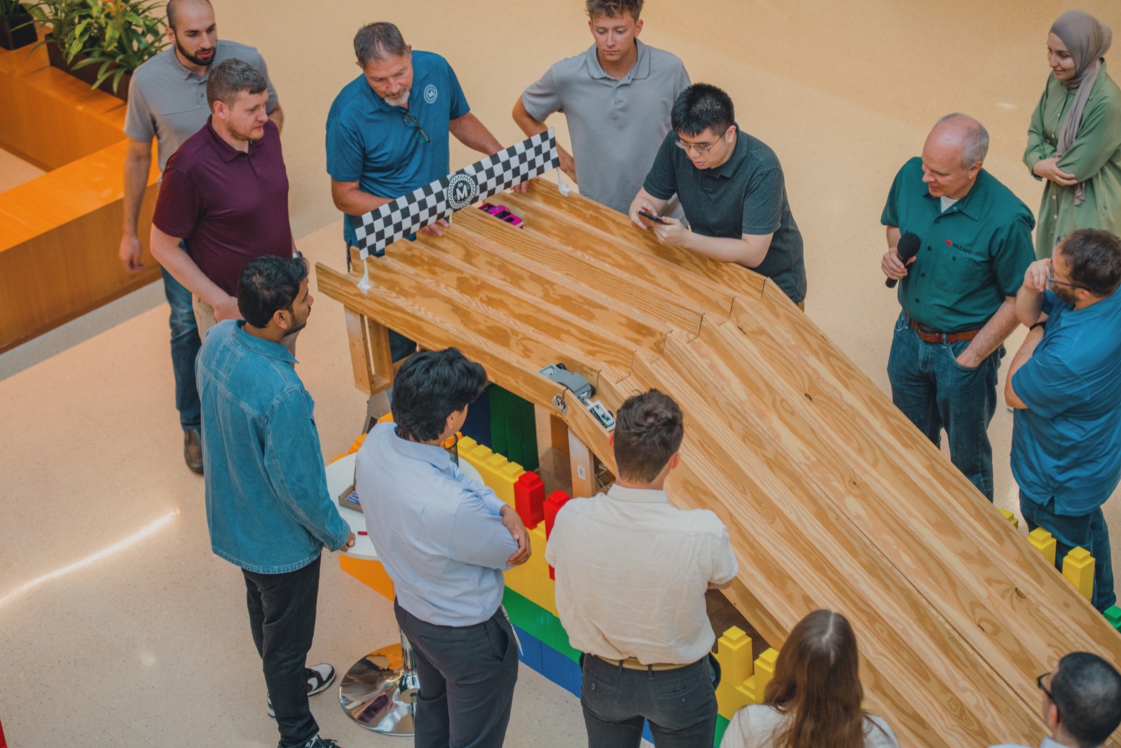 Crowd around a wooden hill-climb ramp as micro cars race