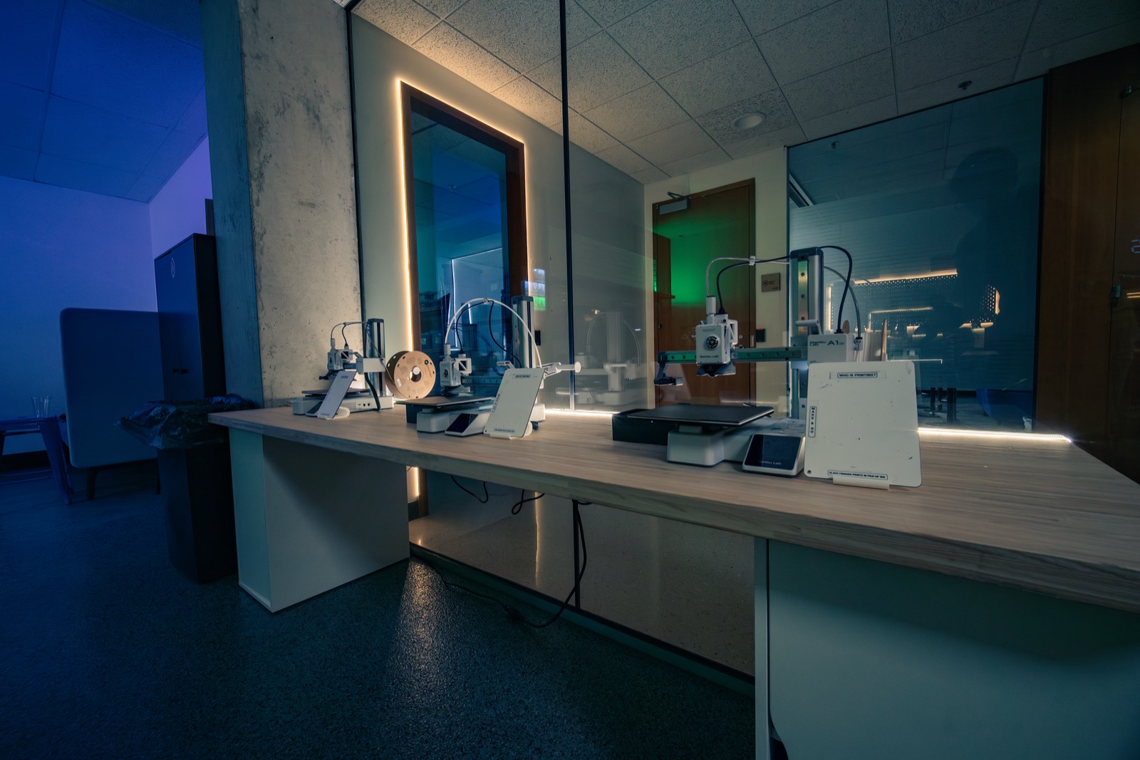 3D printers on a lit counter at night