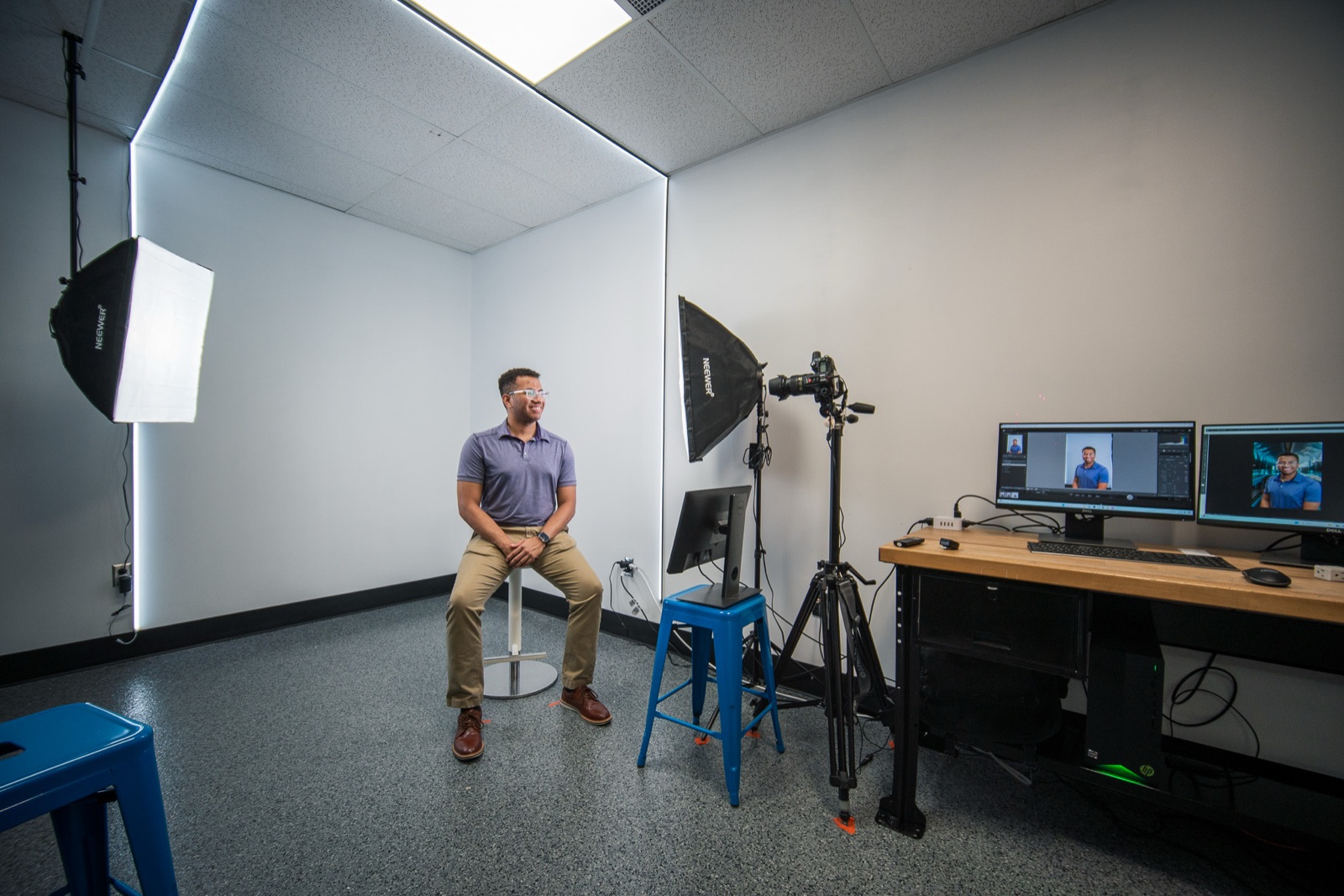 Man seated in a white studio with softboxes