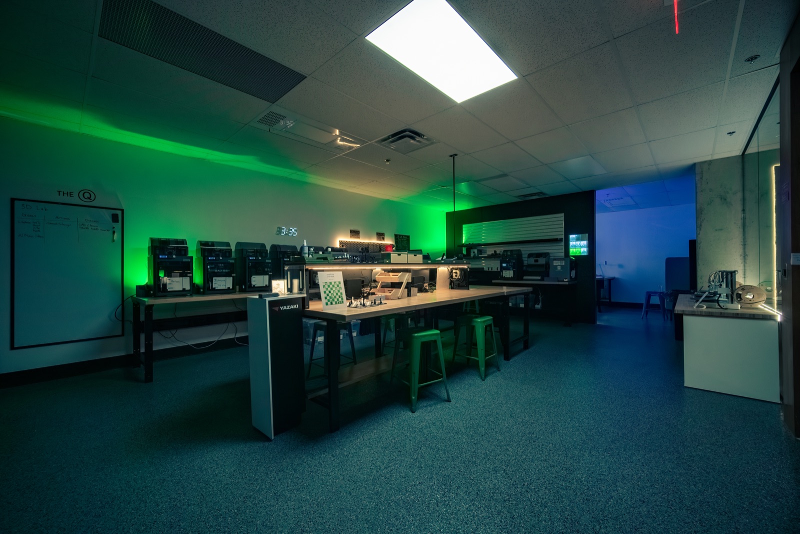 Row of 3D printers under green light