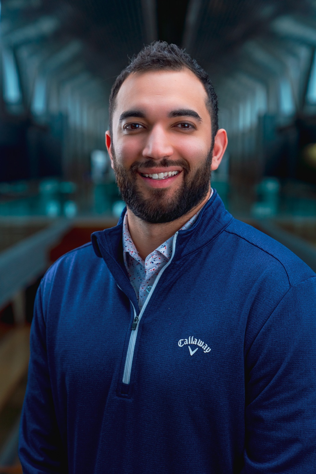 Smiling man in a navy quarter-zip