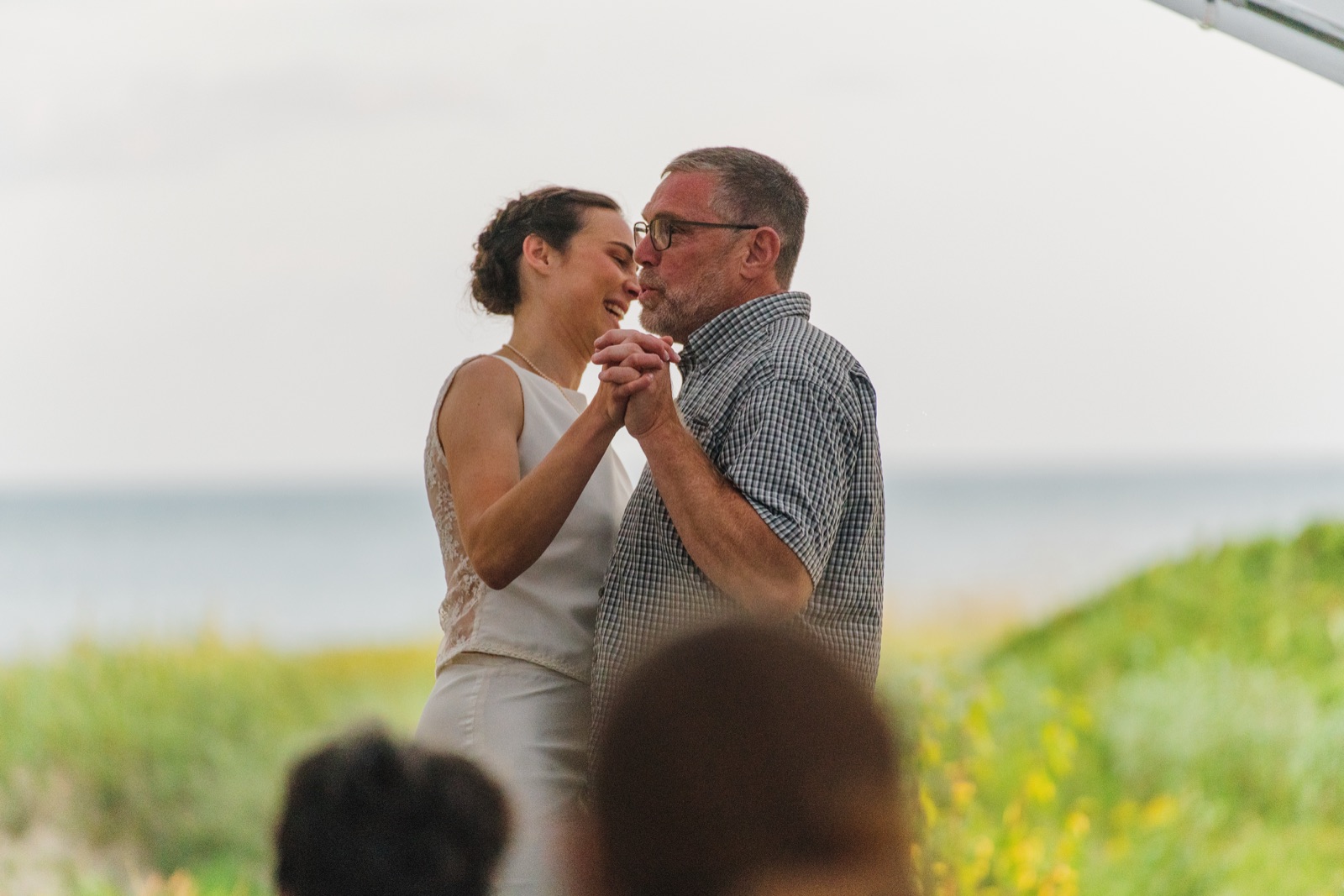 Bride dancing with her father by the lake