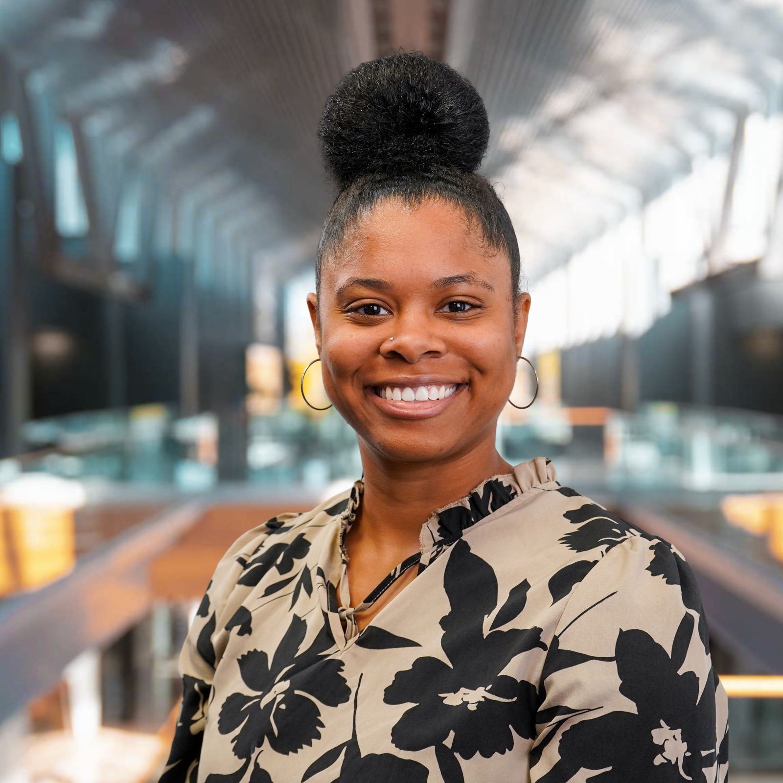 Smiling intern portrait in an atrium