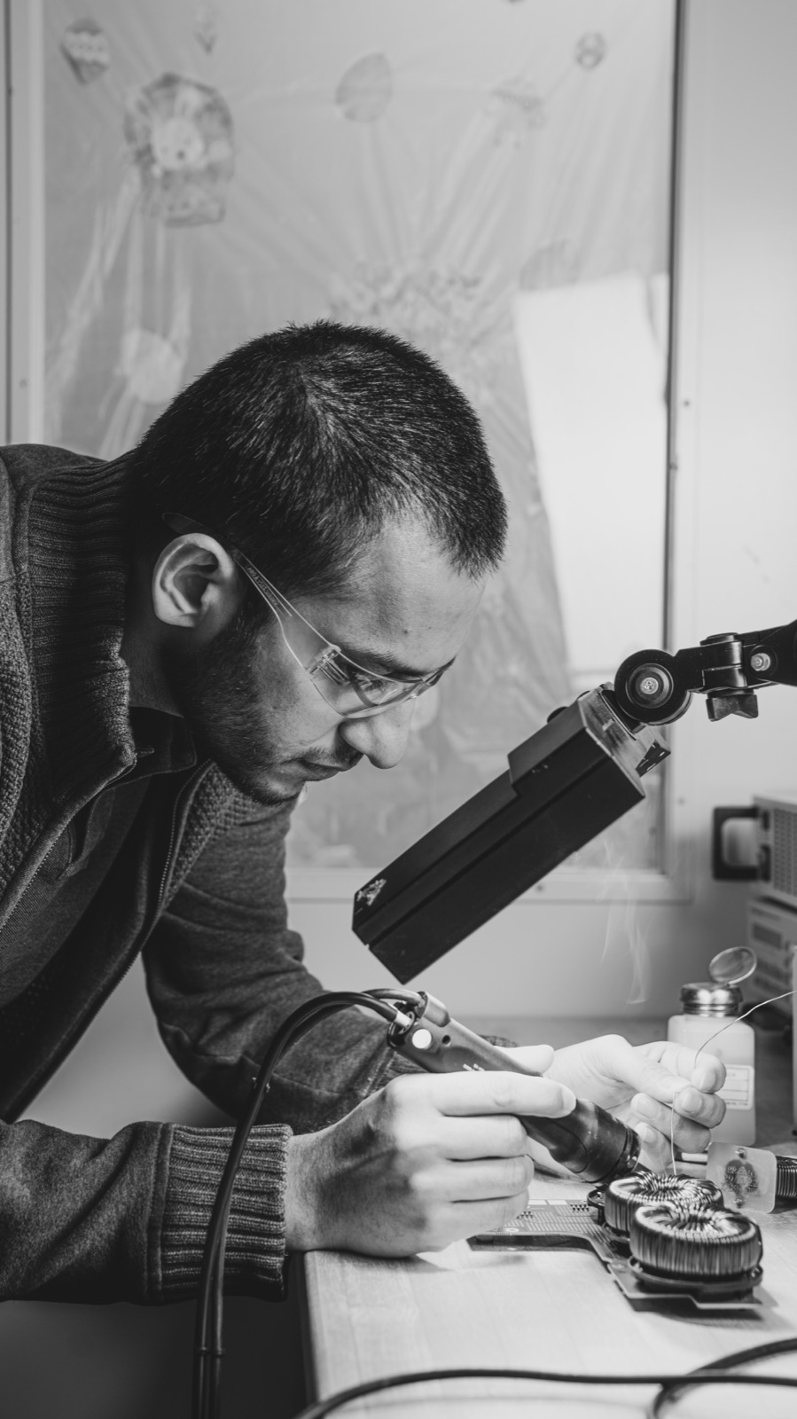 Black and white photo of an engineer using a microscope
